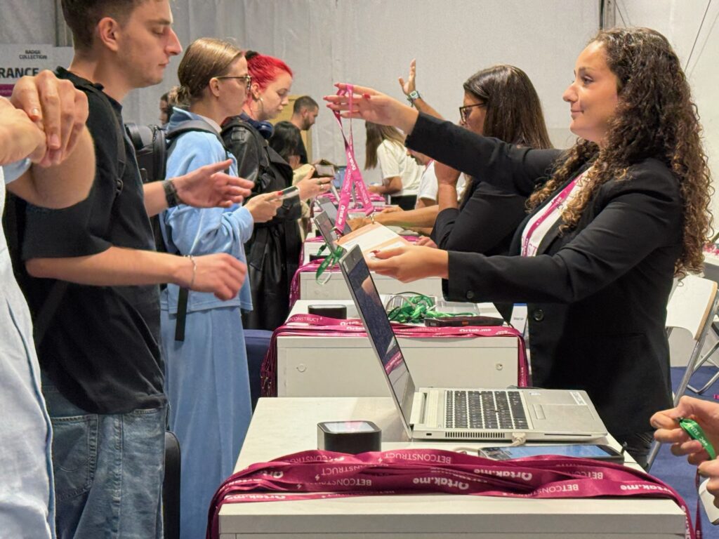 Conference registration desk with attendees receiving badges